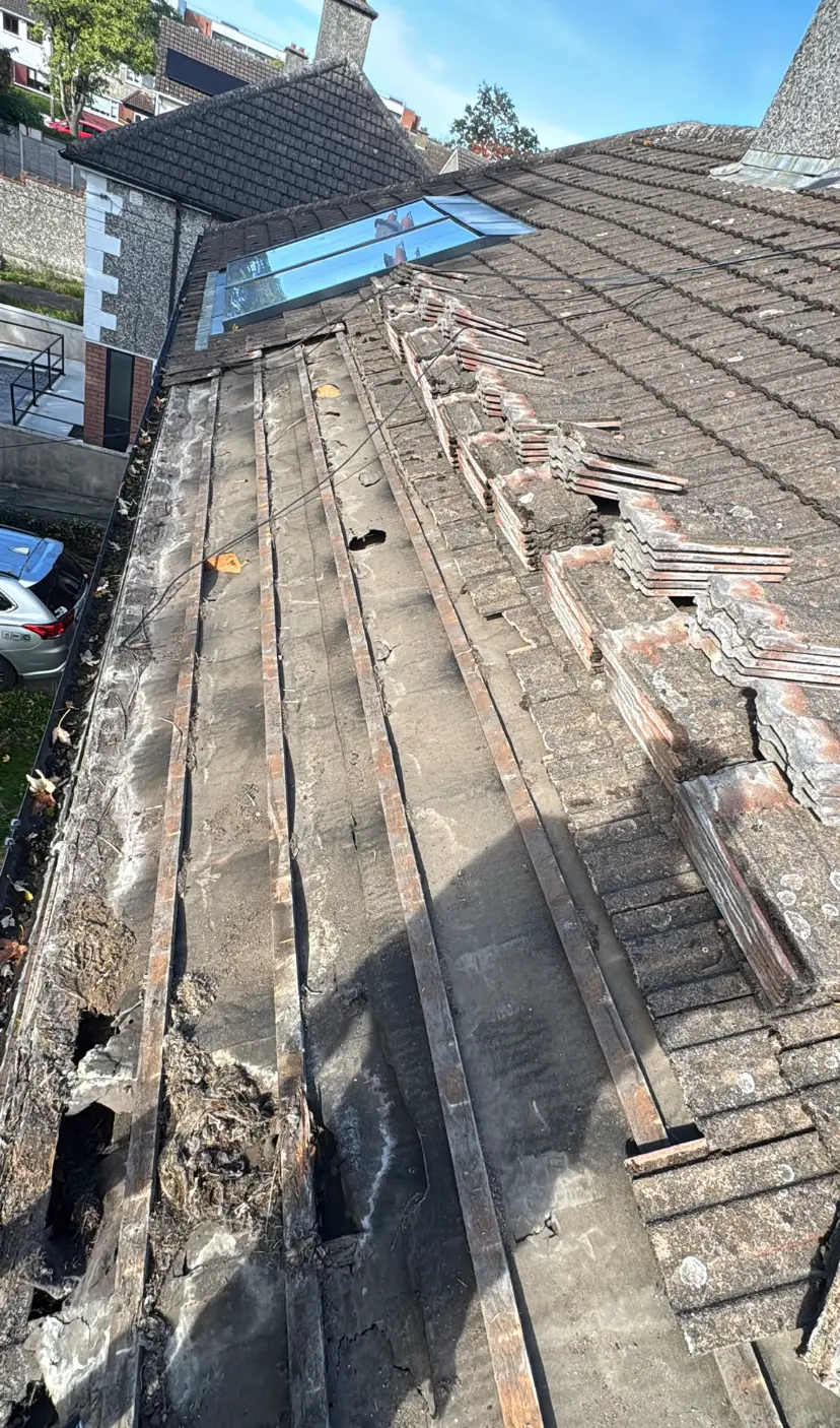 Roof tiles removed beside a roof valley ready for repair